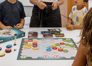 Niños y niñas alrededor de un tablero de un juego de mesa