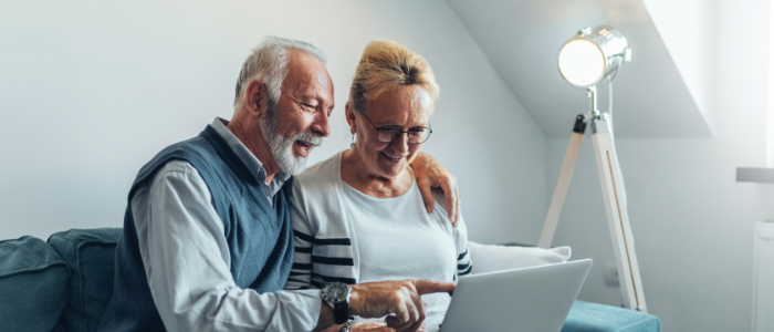 pareja sonriente navegando por internet con un ordenador