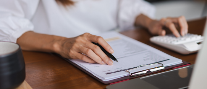 revisión de documentos con bolígrafo en mano y calculadora